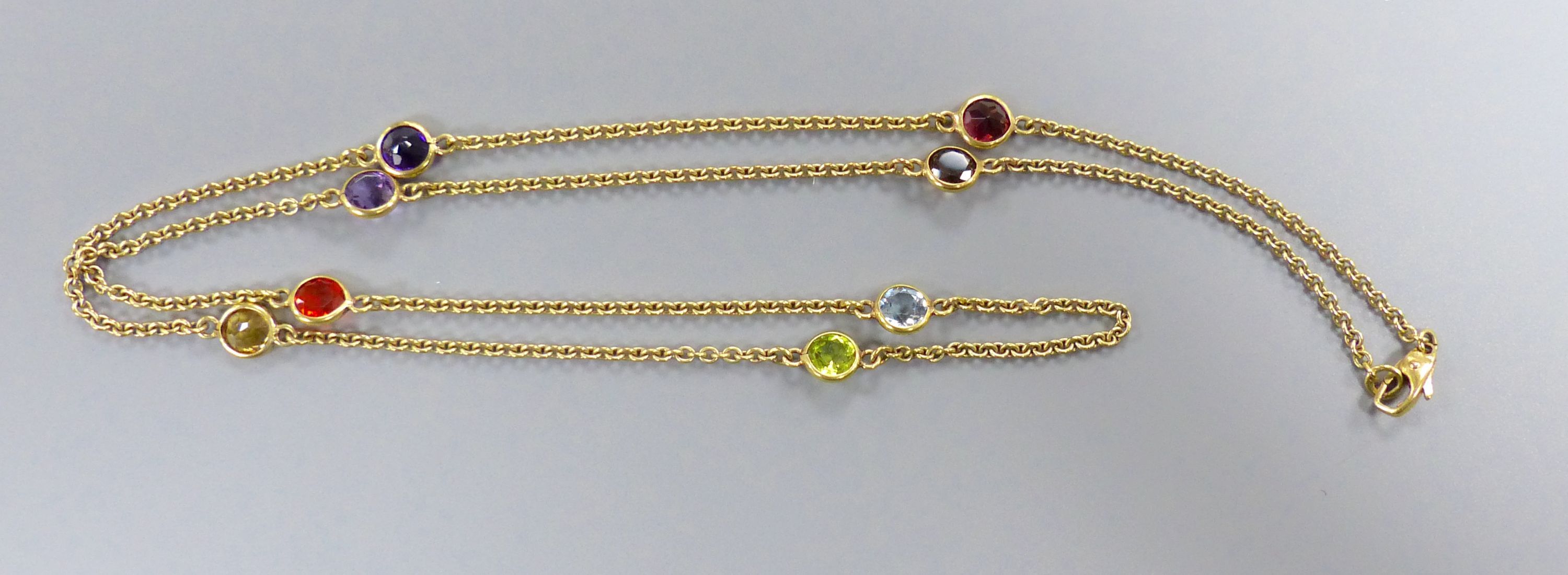 A modern 9ct gold and eight stone multi-gem set 'spectacle' necklace, 60cm, gross 9 grams.